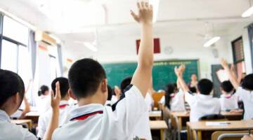 Child raising hand in classroom